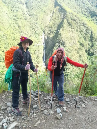 2 personas con sus bastones posando delante de las montañas en el trekking a Salkantay con HA