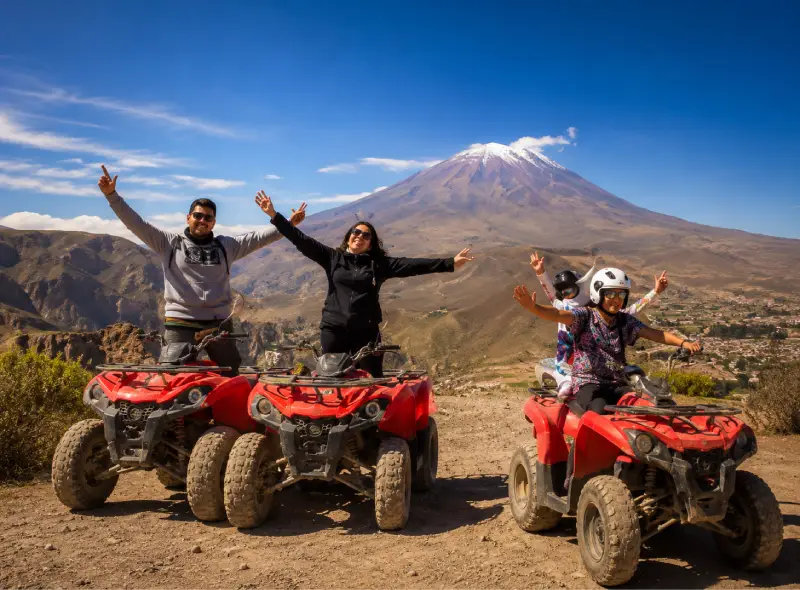 Grupo de viajeros disfrutando un tour en cuatrimotos con paisaje volcánico en Arequipa