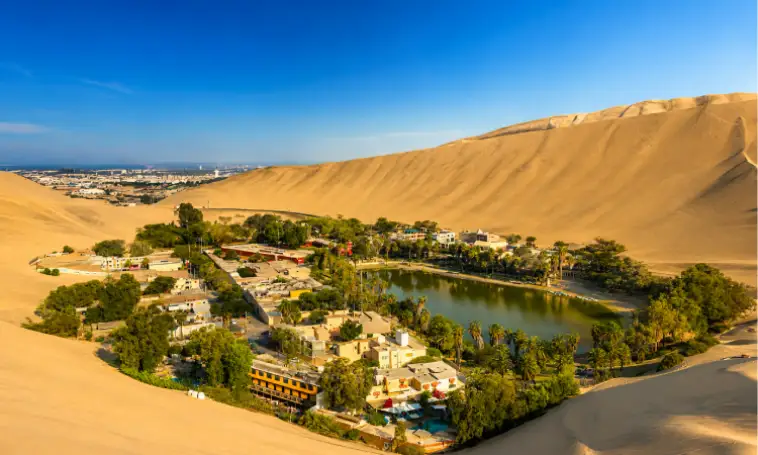 Vista panorámica del Oasis de Huacachina rodeado de dunas durante el tour Paracas e Ica desde Lima