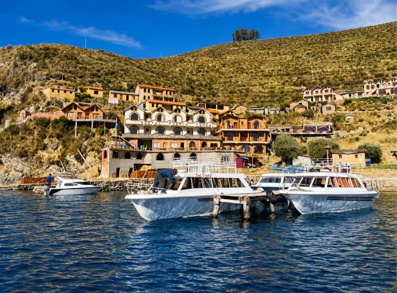 Embarcaciones turísticas junto a un poblado del Lago Titicaca durante la visita a la Isla del Sol